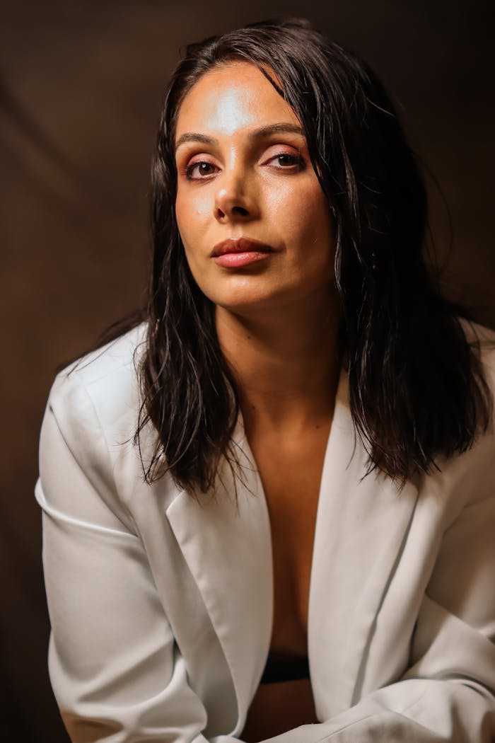 Stunning portrait of a woman in a white blazer with soft lighting creating an artistic mood.